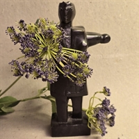menneske-skulptur-sort-metal-armene-ud-til-siden-paa-sokkel-